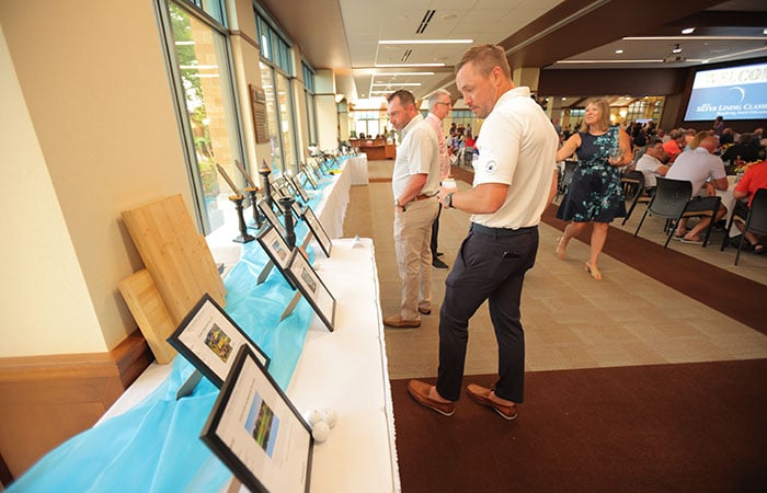 Attendees look at the silent auction items at the event.