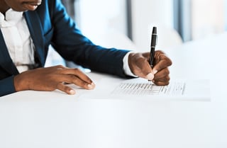 Cropped shot of a businesswoman going through paperwork in a modern office