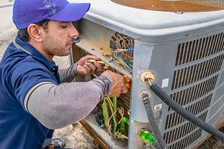 HVAC technician working on unit