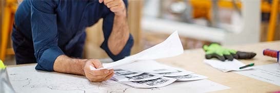 man-looking-over-papers-in-workshop