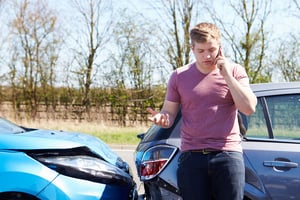 Man makes call from his cell phone after rear-ending another car.