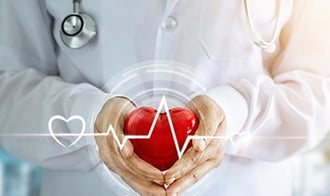 Medical Doctor holds heart shaped stress ball.