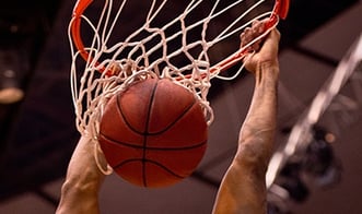 Close up of basketball being dunked through basket.