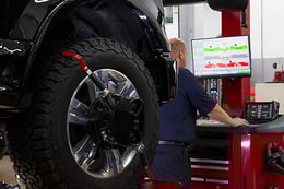 Auto mechanic looks up info on computer.
