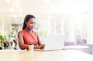 Woman sits at home and logs into laptop