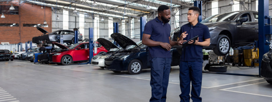 two auto mechanics working in an auto shop