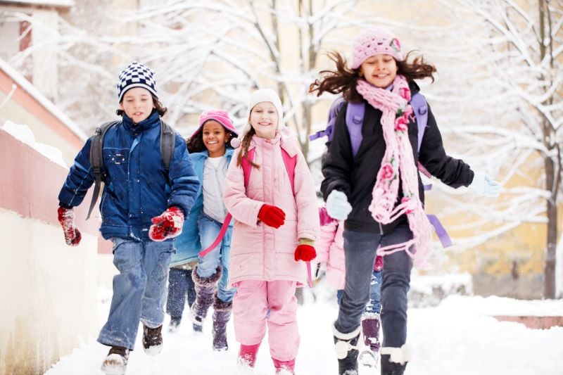 Groupo of children walking through snow.