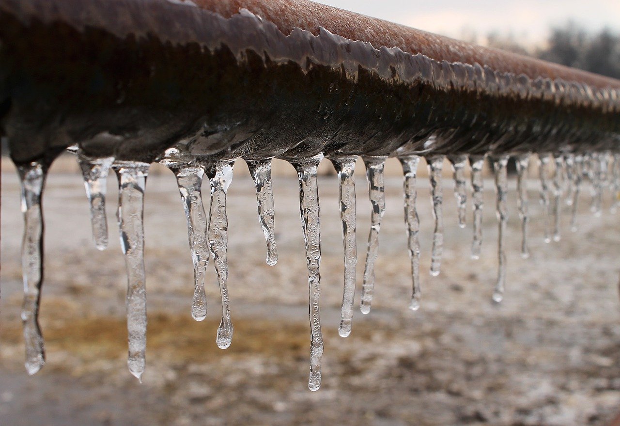 Icicles hanging off a frozen pipe.